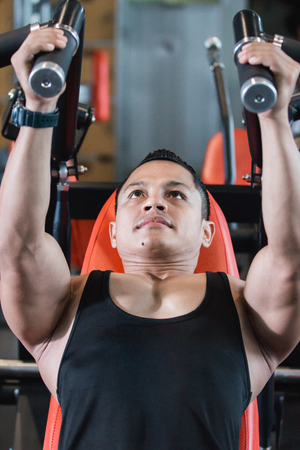 Close up view handsome asian male doing chest exercisesの写真素材
