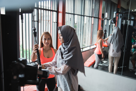 Side view of young asian muslim woman hijab exercising triceps pの写真素材