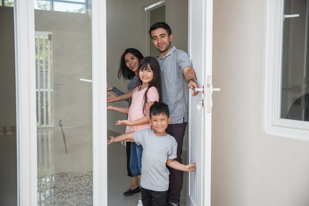 happy family with kids open their house doorの写真素材