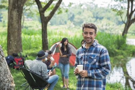 Friends Relaxing Outside Tents On Campingの写真素材