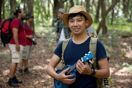 male with ukulele hiking to the forestの写真素材