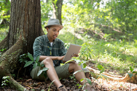 man hiker take a break and using tablet pcの写真素材
