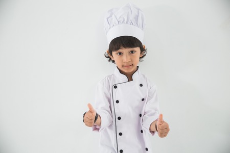 little kid profession uniform pretending to be a chefの写真素材