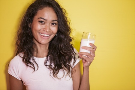beautiful asian woman with a glass of fresh milkの写真素材
