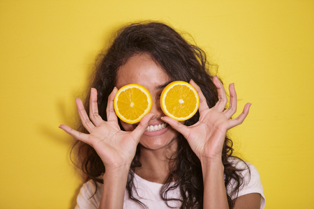 expressive asian woman with slices of fresh lemonの写真素材