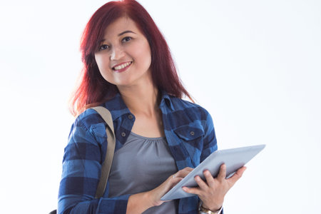 Female redhead college student holding tablet pc