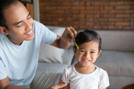dad combing baby girl hairの写真素材