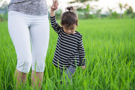 happy young asian enjoying their time in paddy rice fieldの写真素材