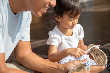 portrait of dad and daughter cleaning shoes together. positive parenting conceptの写真素材