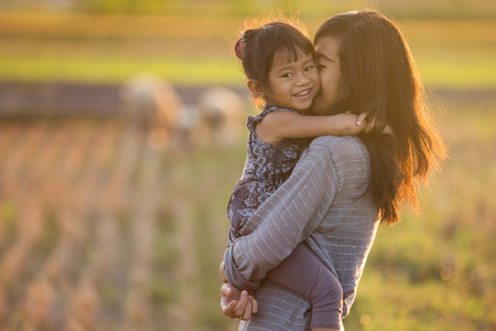 mom and daughter in beautiful sunset sceneryの写真素材