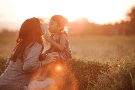 mom and daughter in beautiful sunset sceneryの写真素材