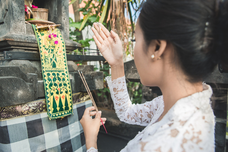 balinese woman doing ritual offering canang sari and praying atの写真素材