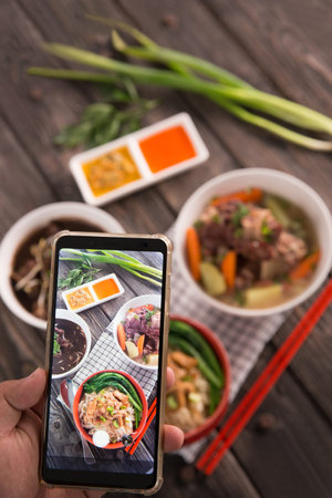 hand taking picture of delicious traditional food