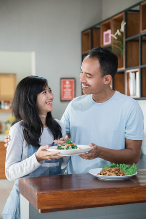 asian couple in the kitchen preparing foodの写真素材