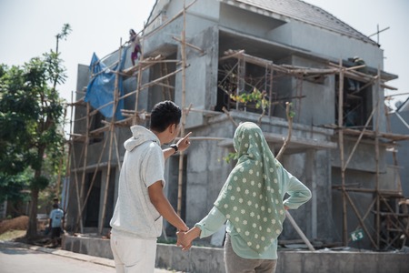 muslim couple in front of unfinished houseの写真素材