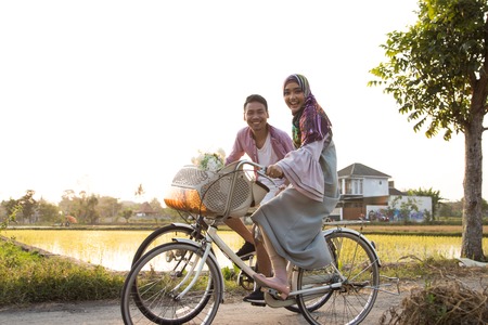 muslim couple riding a bikeの写真素材