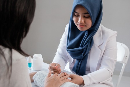 Beautician using a cuticle pusherの写真素材