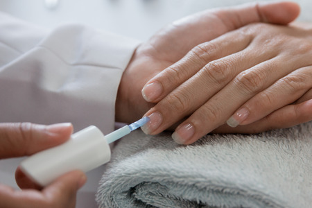 Beautician using a nail polish giving customer service a manicure at salonの写真素材