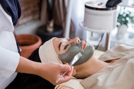 Young woman with facial mask mudの写真素材