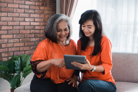 woman using tablet with her mature mom