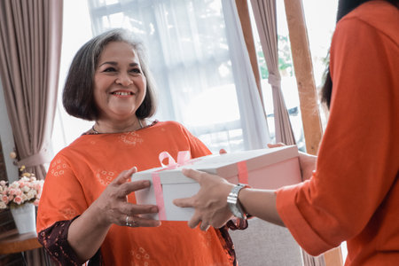 woman giving present to her elderly mother