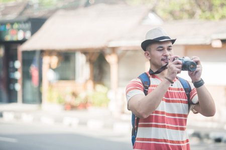 young backpacker taking photos using vintage camera