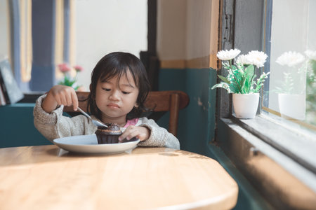 Asian little girl eating cakeの写真素材