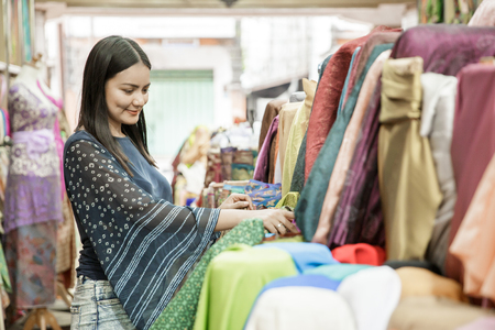 beautiful woman choosing material for clothesの写真素材