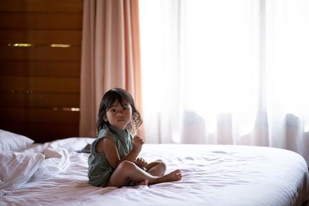 portrait a little girl alone in bedの写真素材