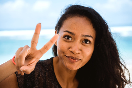 portrait of a happy exotic woman showing peaceの写真素材