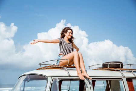 beauty woman raise hands enjoy blow wind on the roofの写真素材