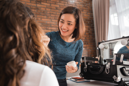 make up artist applying gloss on woman lipsの写真素材