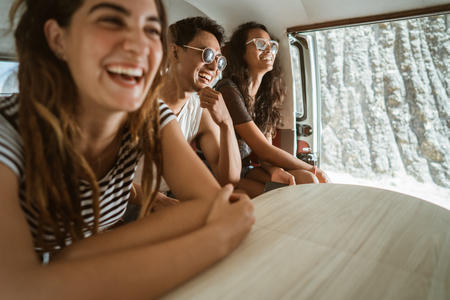 Carefree hipster having fun inside retro van on tripの写真素材