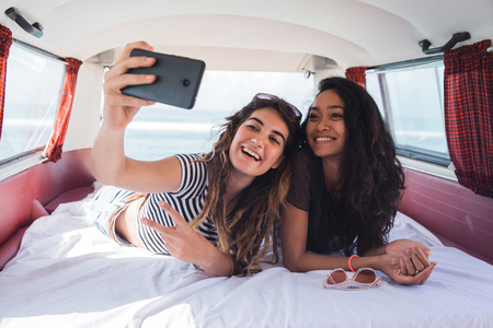 Two girls selfie with smile lay downの写真素材