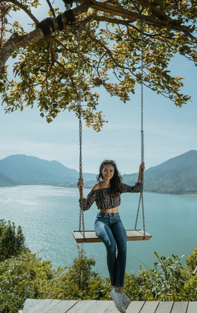 asian woman portrait on a swing with beautiful nature backgroundの写真素材