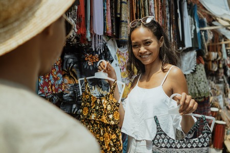 woman buying some clothes in souvenir shopの写真素材