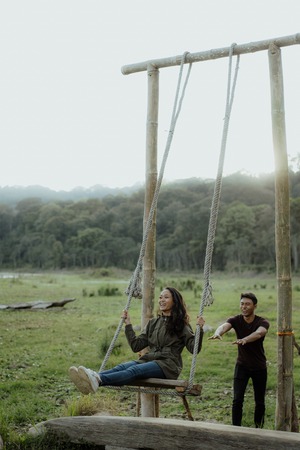 asian woman swinging in natureの写真素材
