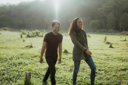 happy young asian couple in countryside enjoying natureの写真素材