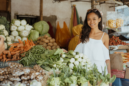 woman while in the market buying some vegetableの写真素材