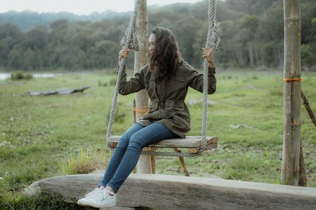 asian woman swinging in natureの写真素材