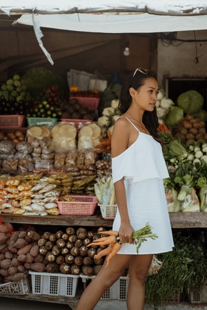 woman while in the market buying some vegetableの写真素材