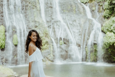 stylish young woman taking picture for social media in waterfallの写真素材