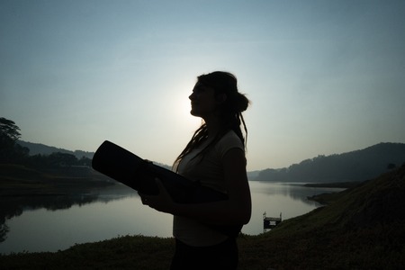 Silhouette of woman carrying mattressの写真素材