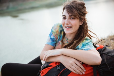 Beautiful woman lay on grass enjoy the traveling, looking cameraの写真素材