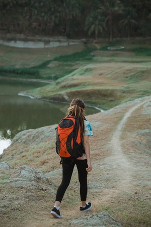 Woman hiker alone enjoy the beauty of nature, back viewの写真素材