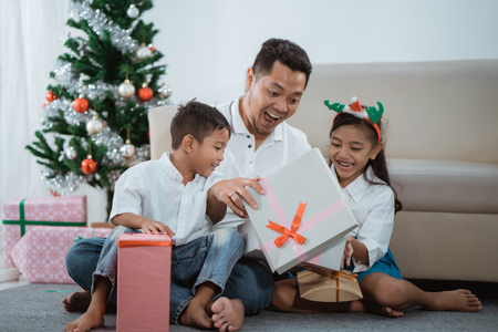 surprise family opening a christmas gifの写真素材