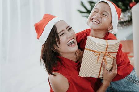 son giving her mother a present during christmasの写真素材