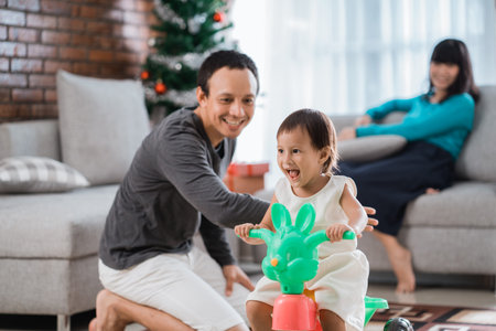 portrait of daughter playing tricycle with father helped