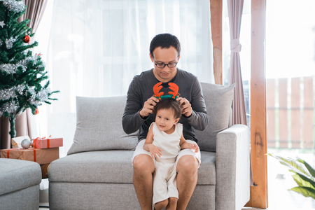 portrait of father helped a little daughter wearing deer headbandの写真素材