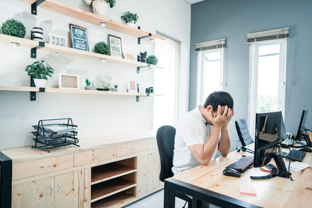 portrait of worker alone on the office with serious problemの写真素材